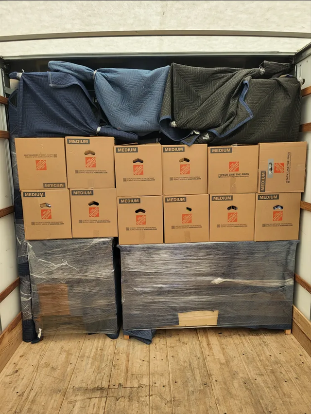 Protected furniture and boxed belongings organized in a moving truck