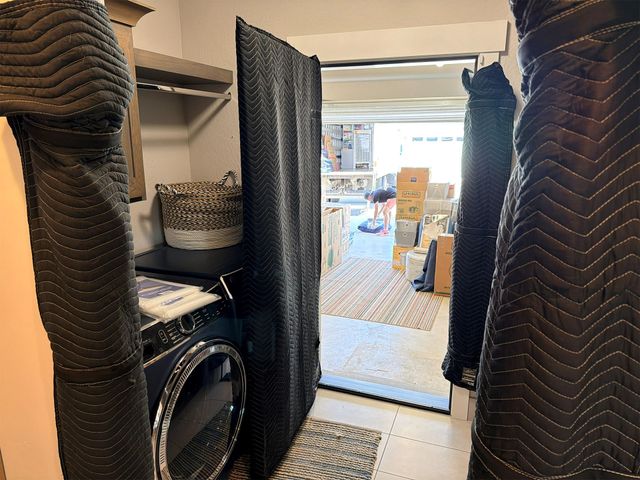 A doorway protected with moving pads beside a household appliance