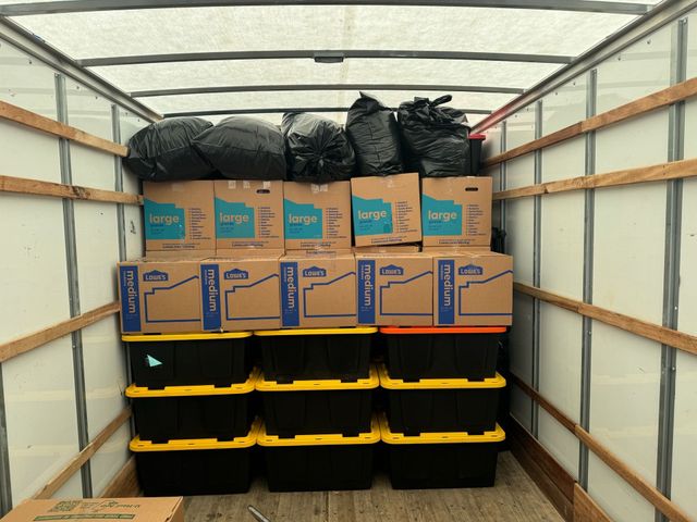 Moving boxes and wrapped household furniture organized inside a truck