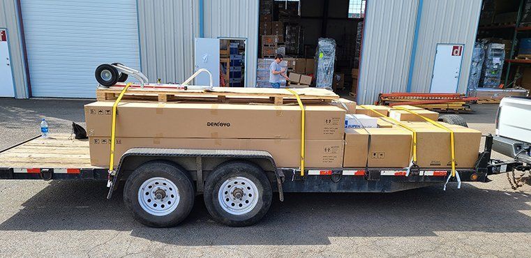 Boxes and household belongings loaded into an open moving trailer